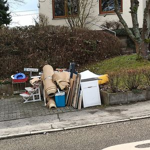 Mobilier vechi, covoare și obiecte voluminoase lăsate pe marginea trotuarului pentru colectare
