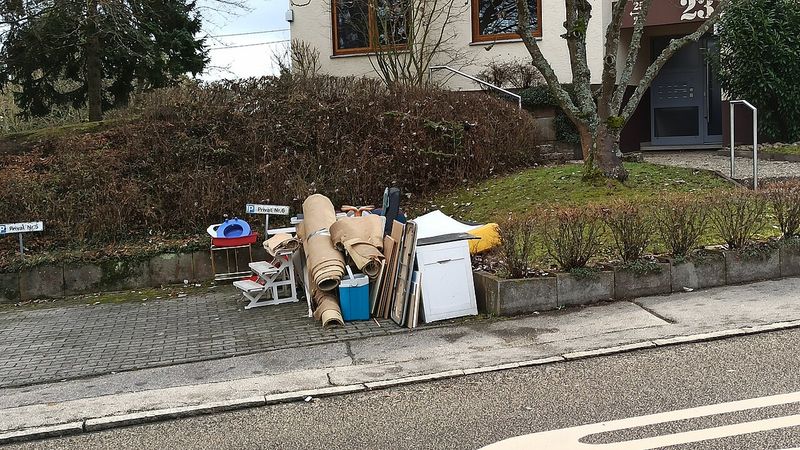 Mobilier vechi, covoare și obiecte voluminoase lăsate pe marginea trotuarului pentru colectare